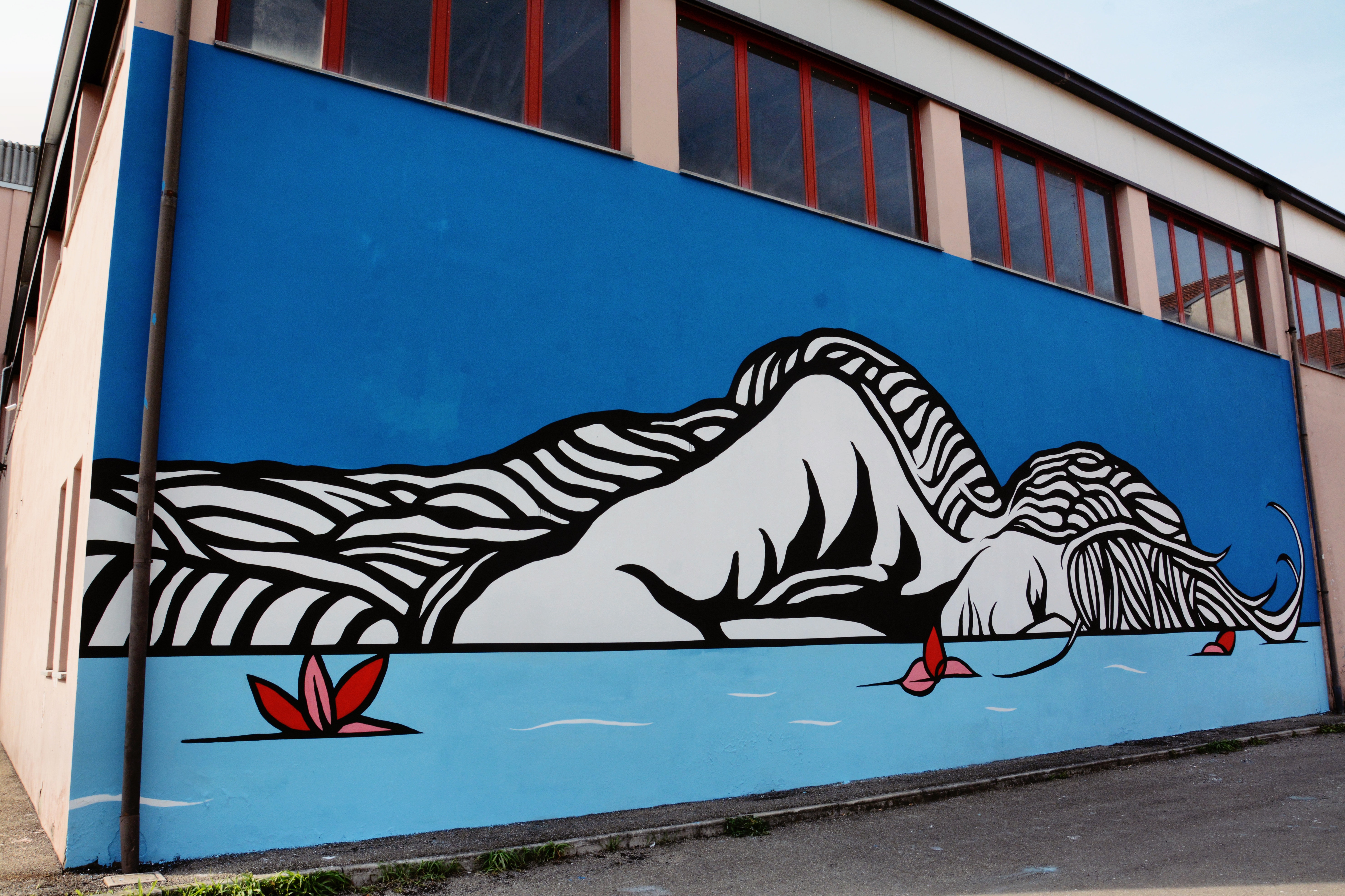 Una donna riversa con gli occhi chiusi: il murales contro la violenza