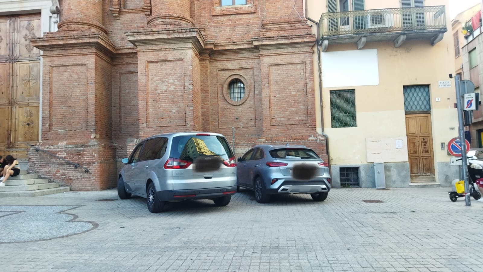 Una chiesa, monumento della città, e quelle auto con il muso attaccato alla facciata