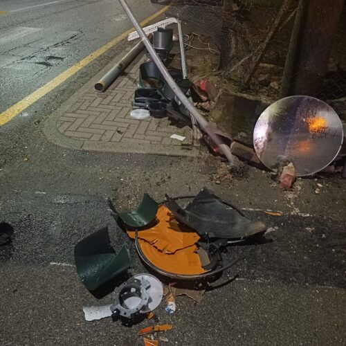 Esce di strada, abbatte un semaforo e finisce in un cortile