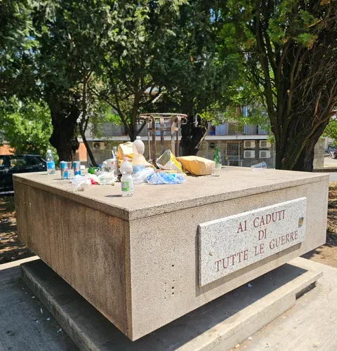 La foto: il monumento ai Caduti trattato come un meschino arredo dove accumulare rifiuti
